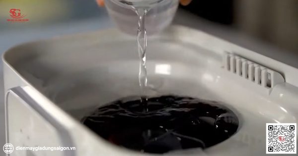 Đổ nước vào khay tiệt trùng trước khi tiệt trùng bình sữa bằng lò vi sóng